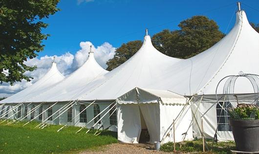 tall green portable restrooms assembled at a music festival, contributing to an organized and sanitary environment for guests in Old Westbury